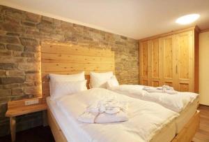 上施陶芬阿尔高克劳特兰酒店的卧室配有一张白色大床和石墙