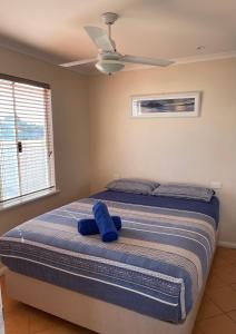 卡那封内陆绿洲旅行车公园的一间卧室配有一张带蓝色枕头的床