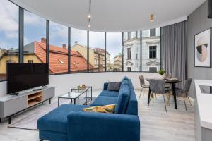 别尔斯克-比亚拉Apartament Prestige Centrum的客厅设有蓝色的沙发和大窗户