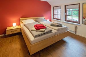 纽哈灵吉塞尔Gulfhof Alt-Addenhausen的一间卧室配有一张带红色毯子的大床