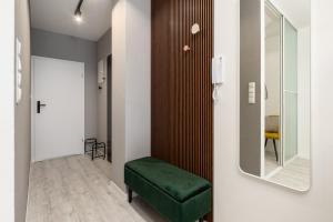 别尔斯克-比亚拉Apartamenty Prestige Centrum的走廊上设有绿色长椅和镜子