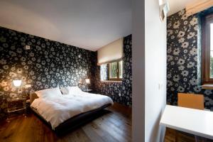 莫罗达尔巴Le Civette的一间卧室配有床和壁纸覆盖的墙壁