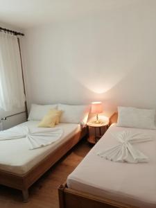 德拉马利Apartments with a parking space Dramalj, Crikvenica - 5592的一张桌子上灯的房间里两张床铺