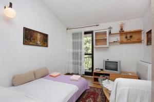 苏佩塔尔Apartments with a parking space Supetar, Brac - 5653的小房间设有两张床和电视