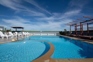 梅尔皮姆Avatara A condominium B61 with sea view的一个带白色椅子和蓝天的大型游泳池