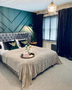 科尔切斯特Cuckoo Rooms的一间卧室设有一张蓝色墙壁的大床