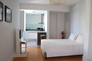 塞亚卡萨多维德艾诺酒店的一间带白色床的卧室和一间厨房