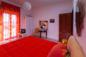托雷法罗利莫尼苏马赫住宿加早餐旅馆的一间卧室配有红色的床和一张书桌
