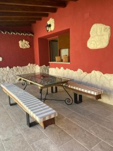 SanchidriánCasa Aurora的红墙前的桌子和长椅
