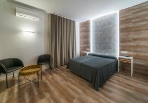 比利亚罗夫莱多卡萨洛伦佐酒店的卧室配有一张床和一张桌子及椅子