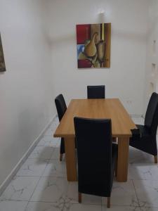 BrikamaTapis Guest House的餐桌、椅子和墙上的绘画