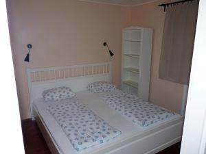 凯希道库什塔尼Levendula apartman的一间卧室配有一张带蓝色和白色枕头的床