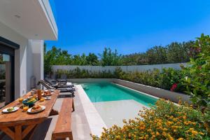 伊利索斯Thalassa Luxury Villa的一个带桌子和游泳池的庭院