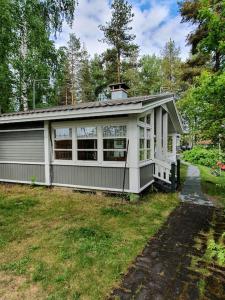 TaipalsaariMökki ja rantasauna Saimaan rannalla的院子中间的小房子