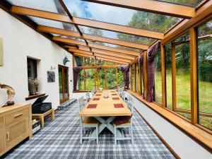 威廉堡Tarmachan Cottage - West Highland Getaway的温室配有桌椅和窗户