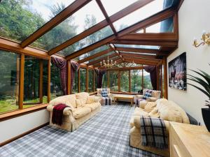 威廉堡Tarmachan Cottage - West Highland Getaway的客厅设有玻璃窗户的温室