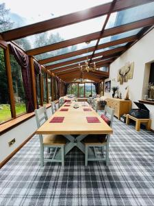 威廉堡Tarmachan Cottage - West Highland Getaway的一间大餐厅,配有桌椅