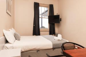 巴旺赫兹Barwon Heads Hotel的酒店客房设有床和窗户。