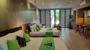 哈巴拉杜瓦Nirmala Villa的一间卧室配有两张带绿色枕头的床