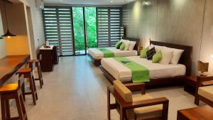 哈巴拉杜瓦Nirmala Villa的一间卧室配有两张床和一张桌子及椅子