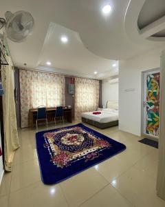 TangkakD' Anjung Inn的卧室配有一张床,地板上铺有蓝色地毯。
