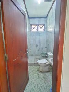 日惹OPY-PELEM 1的一间带卫生间、淋浴和门的浴室