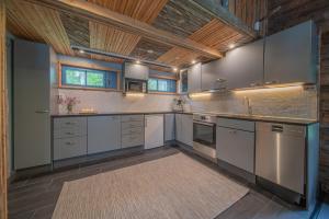 TepsaLapland Lodge的一间设有白色橱柜和木制天花板的大厨房