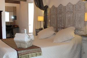 Mirandol-BourgnounacLa maison Cayré的卧室配有一张带白色床单和枕头的大床。