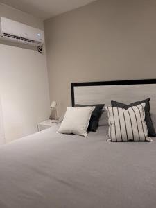 门多萨BE Apartments Vicente的卧室配有带枕头的大型白色床