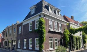登博斯Boutique Hotel Nieuw Uilenburg的一座长着常春藤的大砖房