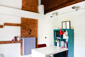Vezza d'AlbaROERooms的一间设有白色书桌和蓝色书架的客房