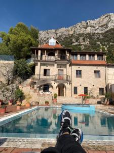 克鲁亚Villa Celaj “The Castle”的坐在带游泳池的房子前的人