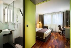 苏黎世Holiday Inn Zürich Messe, an IHG Hotel的酒店客房配有一张床和淋浴