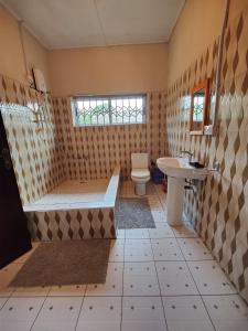 库马西Tumi Hostel的带浴缸、卫生间和盥洗盆的浴室