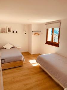 LionzaCasa Mille Sassi的一间卧室设有两张床和窗户。