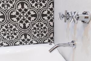 萨尔塔Augusta Deluxe的浴室设有黑色和白色图案的淋浴帘