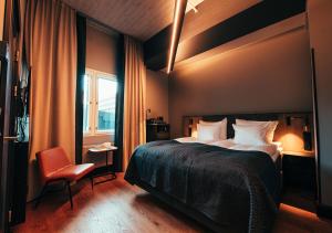 赫尔辛基Hotel Mestari的卧室配有床、椅子和窗户。