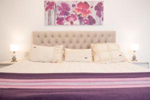 萨尔塔Augusta Deluxe的卧室配有一张白色大床和紫色毯子