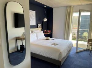 马蒂格Golden Tulip Martigues Provence的卧室配有一张白色大床和镜子