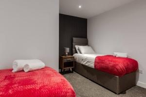 海德Victoria Apt - 2 bedroom Parking Wi-Fi Workers的一间卧室配有两张床和红色毯子