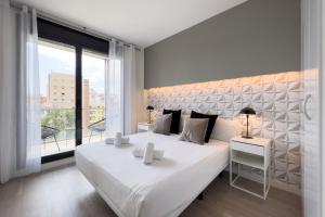 巴塞罗那ChicStays Apartment Vila Olímpica的卧室设有一张白色大床和大窗户