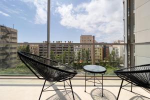 巴塞罗那ChicStays Apartment Vila Olímpica的窗前的两把椅子和一张桌子