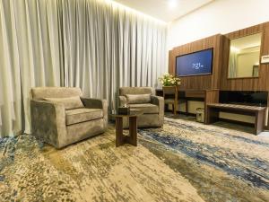 吉达White Diamond Hotel Sari的客厅配有两把椅子和电视