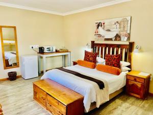 NelspoortTravalia Guest Farm的一间卧室配有一张带橙色枕头的大床
