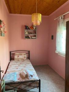 VergiaOur Country House的卧室配有一张粉红色墙壁上的床铺
