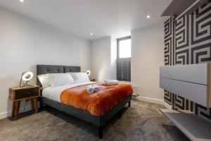 海德Victoria Place - 3-bed apartment, parking, Wi-Fi的一间卧室配有一张带橙色毯子的床