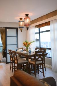 哥打京那巴鲁Petronella Suites Apartment @ Jesselton Quay的一间带桌椅和窗户的用餐室