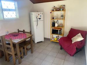 坎波斯杜若尔当Chalé da Araucária的厨房配有桌子、冰箱和椅子