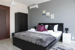 哥鲁拜克Horizont Dedine的一间卧室配有一张带紫色枕头的大床