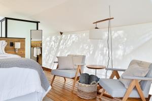 彼得罗波利斯Glamping Cabanas do Vale的一间卧室配有一张床、两把椅子和一张桌子